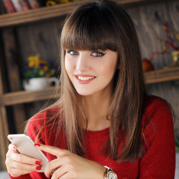 Girl reading SMS on mobile phone Dunwoody Dental Health care