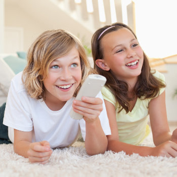 Pediatric Dentistry Roswell siblings watching TV on floor care