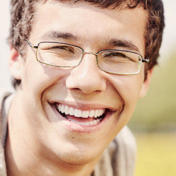 Young man with glasses smiling Dunwoody Dental Health patient